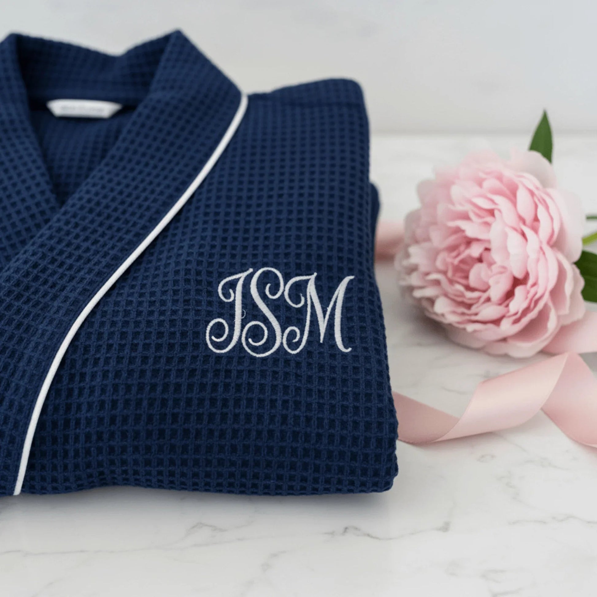 Navy waffle robe close-up with white piping and 'JSM' monogram